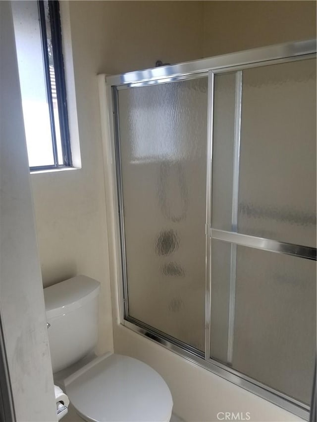 full bath featuring toilet and enclosed tub / shower combo