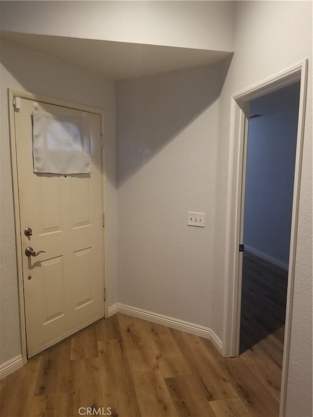 interior space with baseboards and wood finished floors
