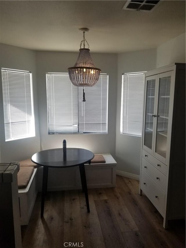 dining room featuring baseboards, a chandelier, wood finished floors, and visible vents