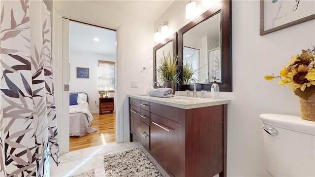 bathroom featuring toilet, vanity, and tile patterned flooring