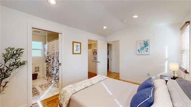 bedroom featuring lofted ceiling and light hardwood / wood-style flooring