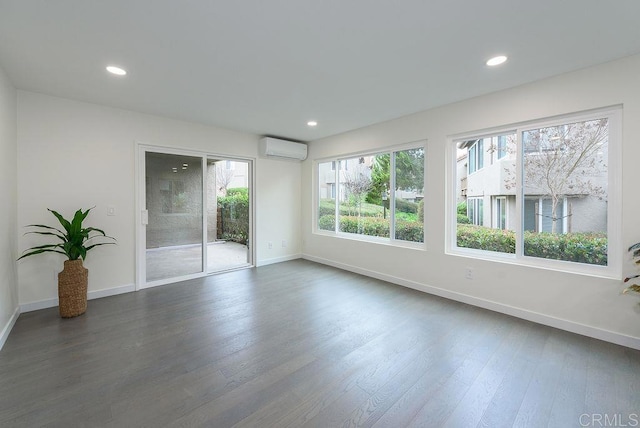 spare room with dark wood-type flooring and a wall mounted AC