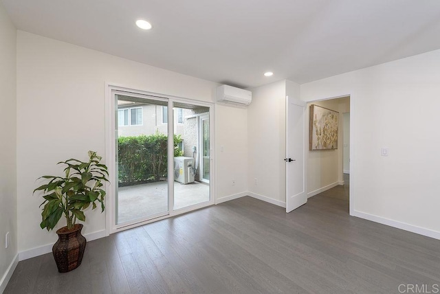 empty room with dark wood-type flooring and an AC wall unit