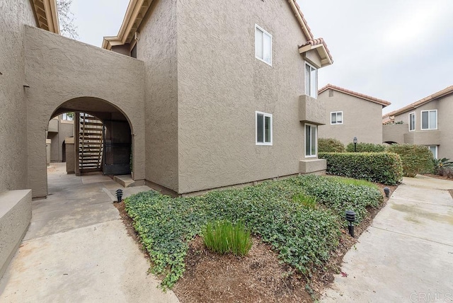 view of property exterior with stairway and stucco siding