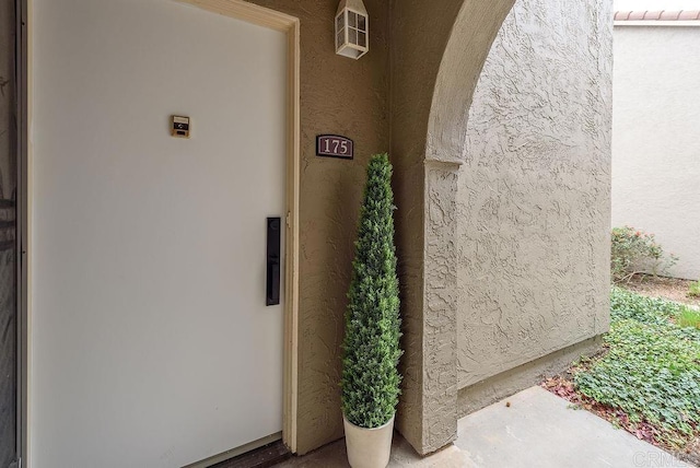 property entrance featuring a tiled roof and stucco siding