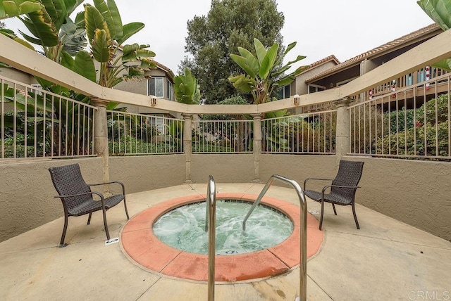 view of swimming pool featuring a community hot tub, a patio, and fence