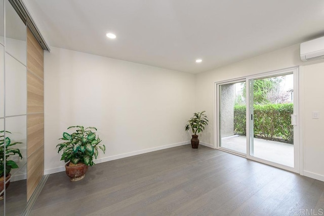 unfurnished room featuring recessed lighting, a wall mounted AC, baseboards, and wood finished floors