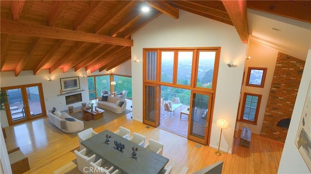 living room with high vaulted ceiling, a large fireplace, beamed ceiling, and wooden ceiling