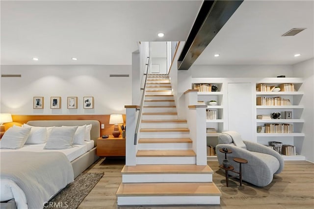 bedroom featuring beam ceiling and light wood-type flooring