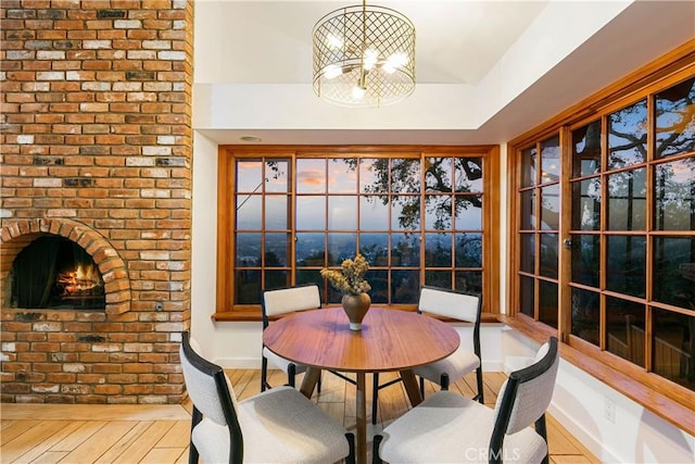 unfurnished dining area with a brick fireplace and light hardwood / wood-style flooring