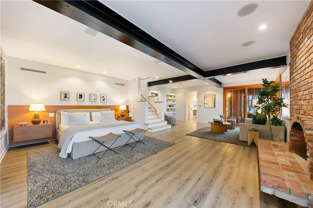 bedroom with light hardwood / wood-style flooring and beamed ceiling