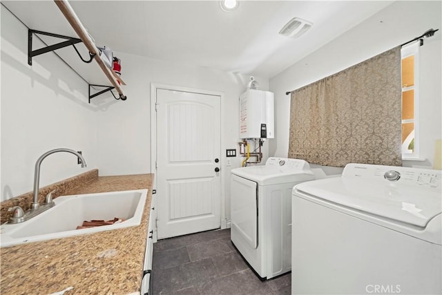 laundry area featuring washer and dryer, water heater, and sink