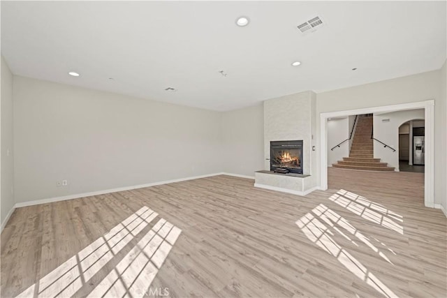 unfurnished living room featuring a fireplace and light hardwood / wood-style flooring