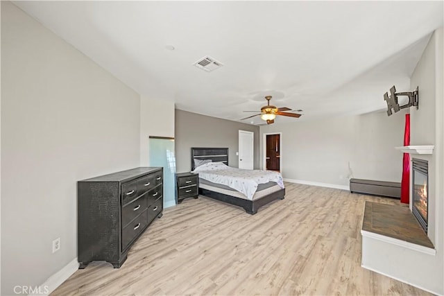 bedroom with ceiling fan, light wood-type flooring, and a baseboard radiator