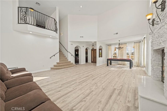 living room featuring billiards, light wood-type flooring, and a high ceiling