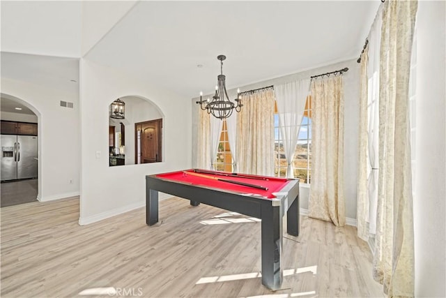 game room with pool table, a notable chandelier, and light wood-type flooring