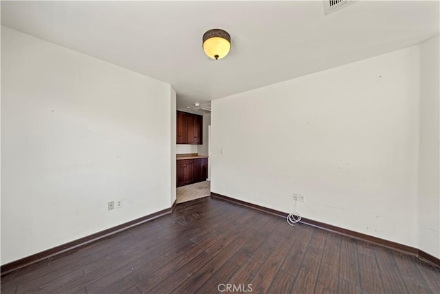 spare room featuring dark hardwood / wood-style flooring