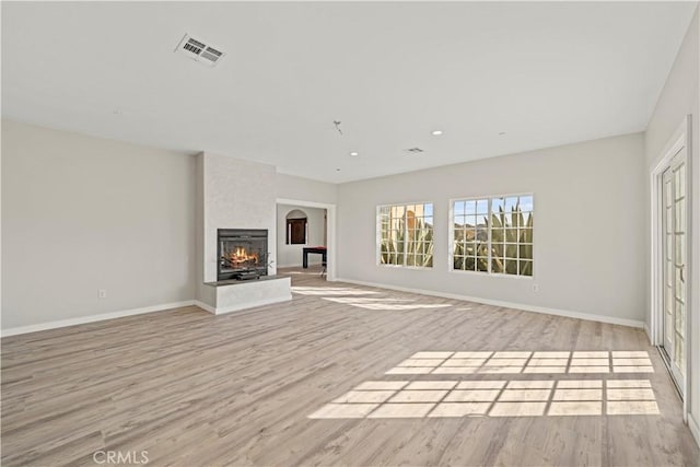 unfurnished living room with a fireplace and light hardwood / wood-style flooring