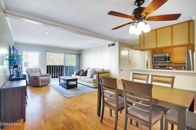 dining space featuring ceiling fan, crown molding, and light hardwood / wood-style flooring