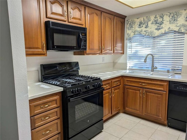 kitchen featuring sink, light tile patterned floors, and black appliances