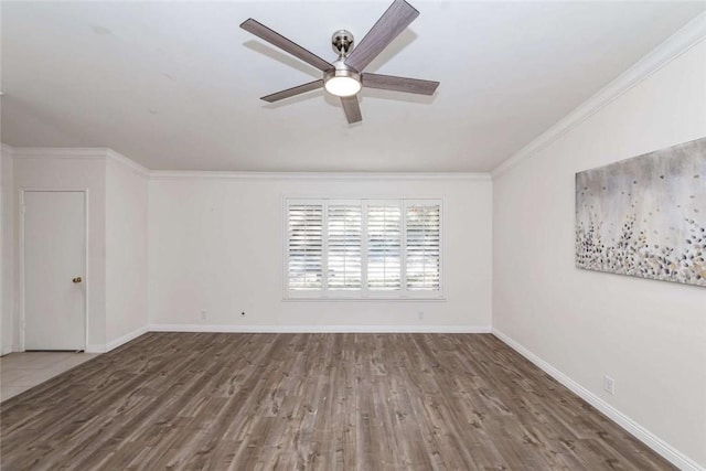 spare room featuring a ceiling fan, baseboards, crown molding, and wood finished floors