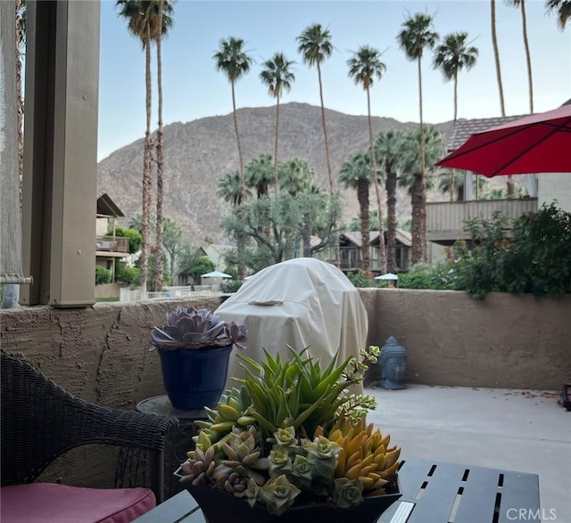 view of patio with fence, a mountain view, and grilling area