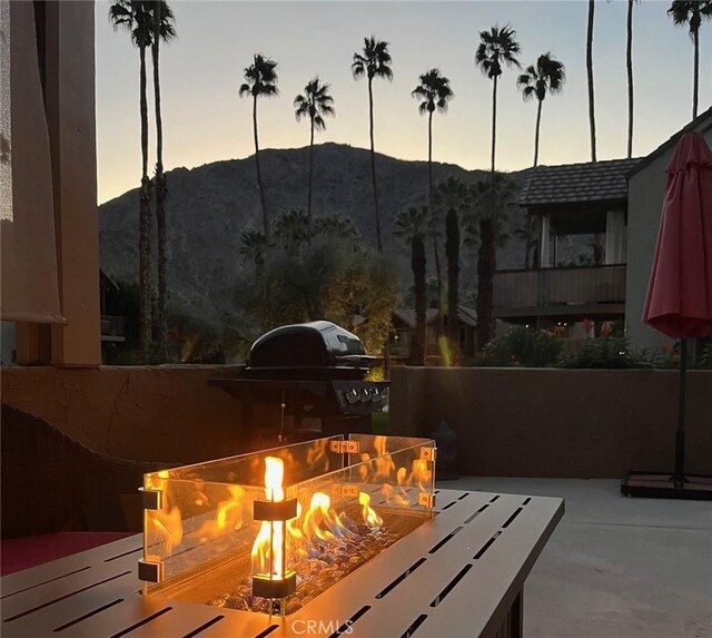 patio terrace at dusk with a mountain view and a fire pit