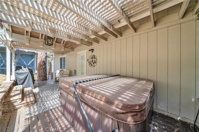 view of patio with grilling area, a hot tub, a pergola, and a wooden deck