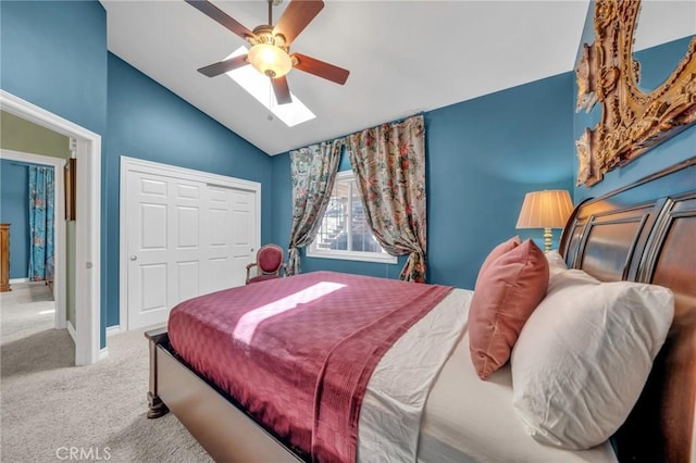 carpeted bedroom featuring ceiling fan, a closet, and lofted ceiling with skylight