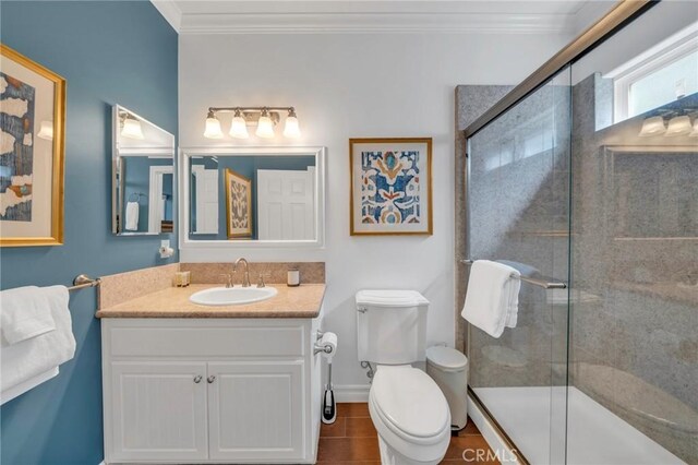 bathroom featuring toilet, a shower with door, tile patterned floors, ornamental molding, and vanity