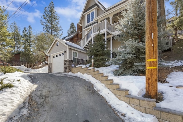 snow covered property featuring a garage and an outdoor structure