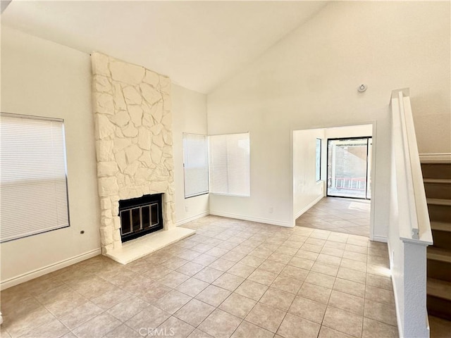 unfurnished living room featuring high vaulted ceiling, light tile patterned floors, and a fireplace