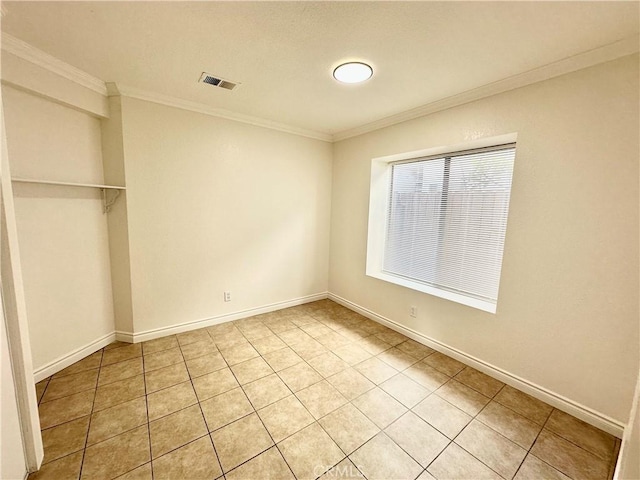 unfurnished bedroom featuring light tile patterned floors and ornamental molding