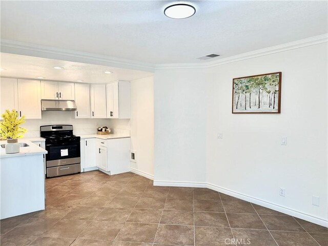 kitchen featuring sink, white cabinets, light stone counters, and stainless steel gas range oven