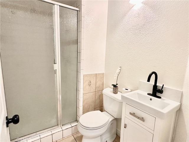 bathroom featuring toilet, vanity, an enclosed shower, and tile patterned flooring