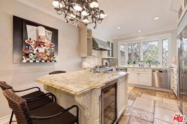 kitchen featuring beverage cooler, extractor fan, a kitchen bar, tasteful backsplash, and stainless steel dishwasher