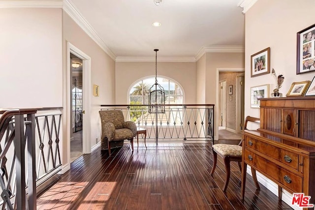 living area with an inviting chandelier, ornamental molding, and hardwood / wood-style flooring