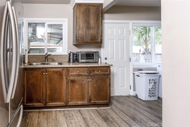 kitchen featuring dark wood-type flooring, stainless steel fridge, and sink