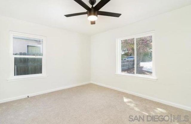 carpeted spare room featuring ceiling fan