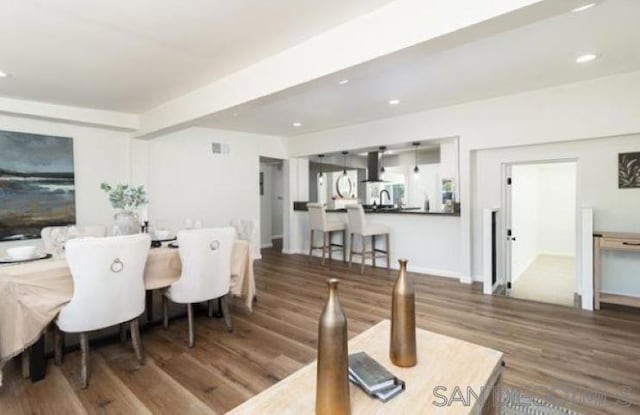 dining space with wood-type flooring