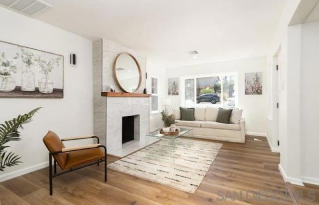 living room featuring hardwood / wood-style floors and a large fireplace