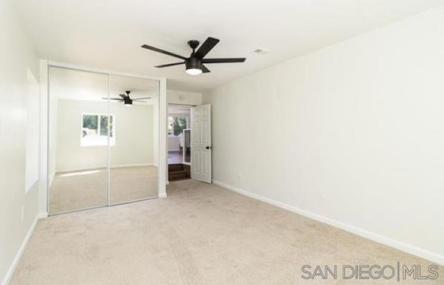 unfurnished bedroom with a closet, ceiling fan, and light carpet