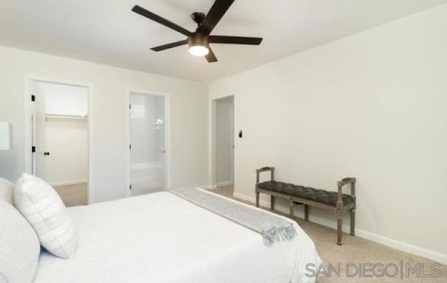 carpeted bedroom with a walk in closet, ensuite bath, a closet, and ceiling fan