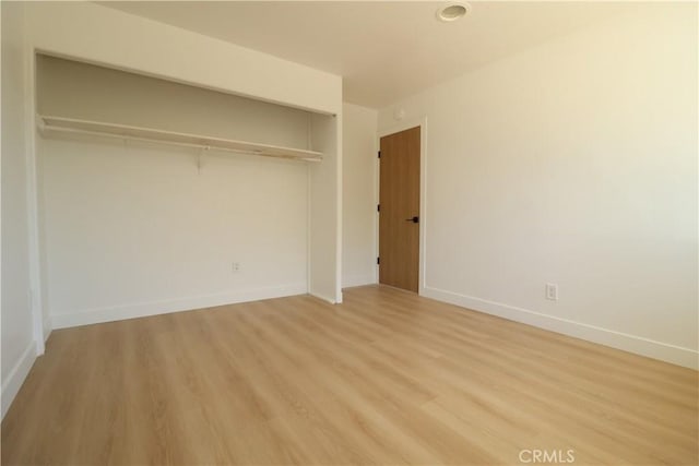 unfurnished bedroom featuring light hardwood / wood-style floors and a closet