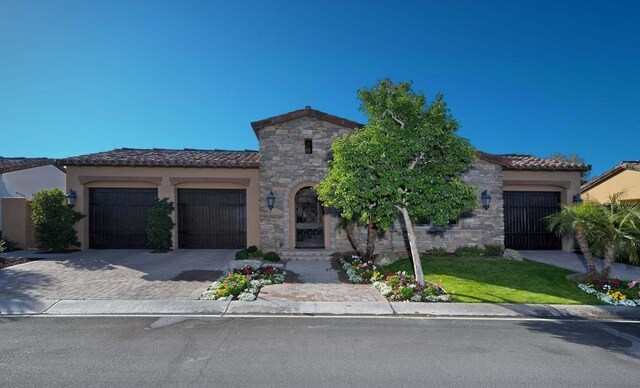 mediterranean / spanish home with a garage