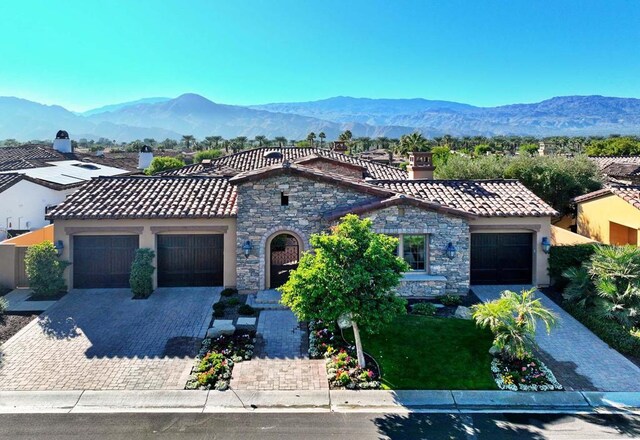 mediterranean / spanish-style home with a mountain view and a garage