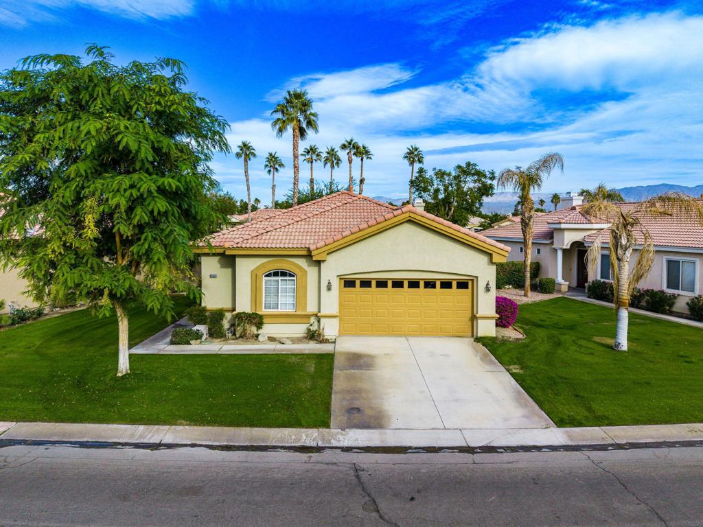 mediterranean / spanish home featuring a garage and a front lawn