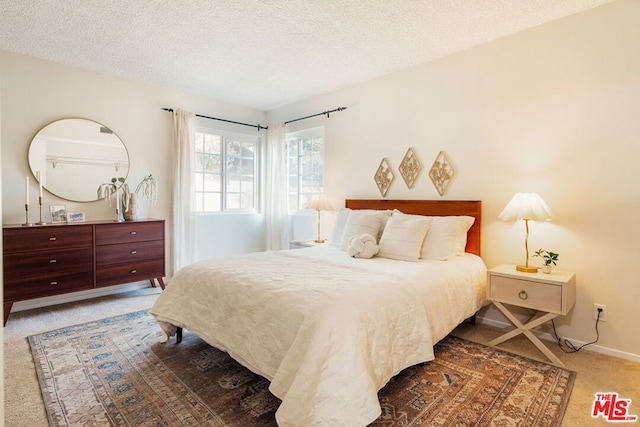 bedroom with a textured ceiling and dark carpet