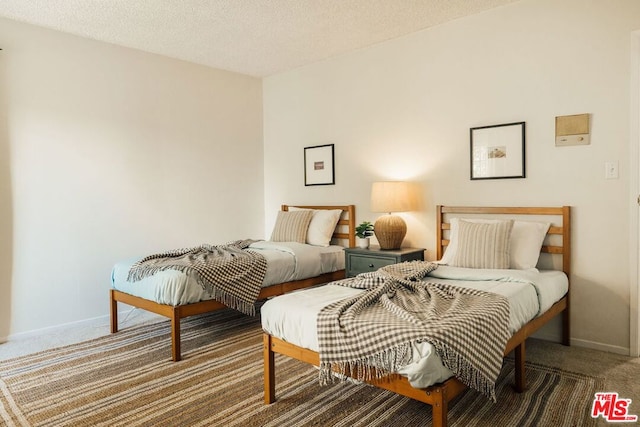 carpeted bedroom featuring a textured ceiling