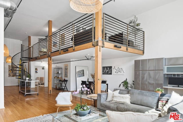 living room featuring a towering ceiling and hardwood / wood-style flooring